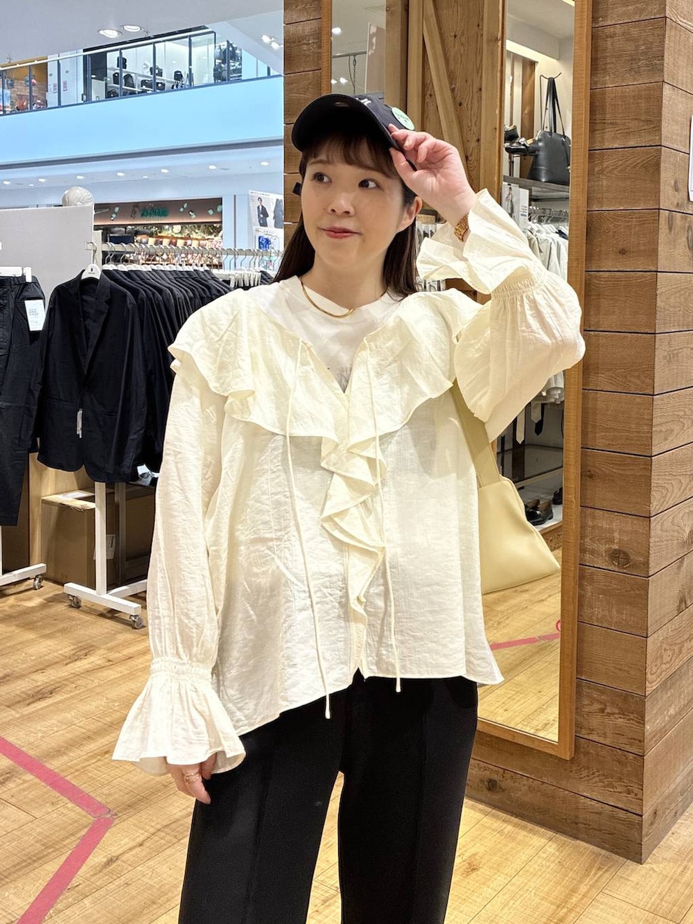 イエロー系のショルダーバッグ、ブラック系のスウェットパンツ、ホワイト系のシャツ/ブラウスを着用したレディースの春コーディネートの3枚目の写真