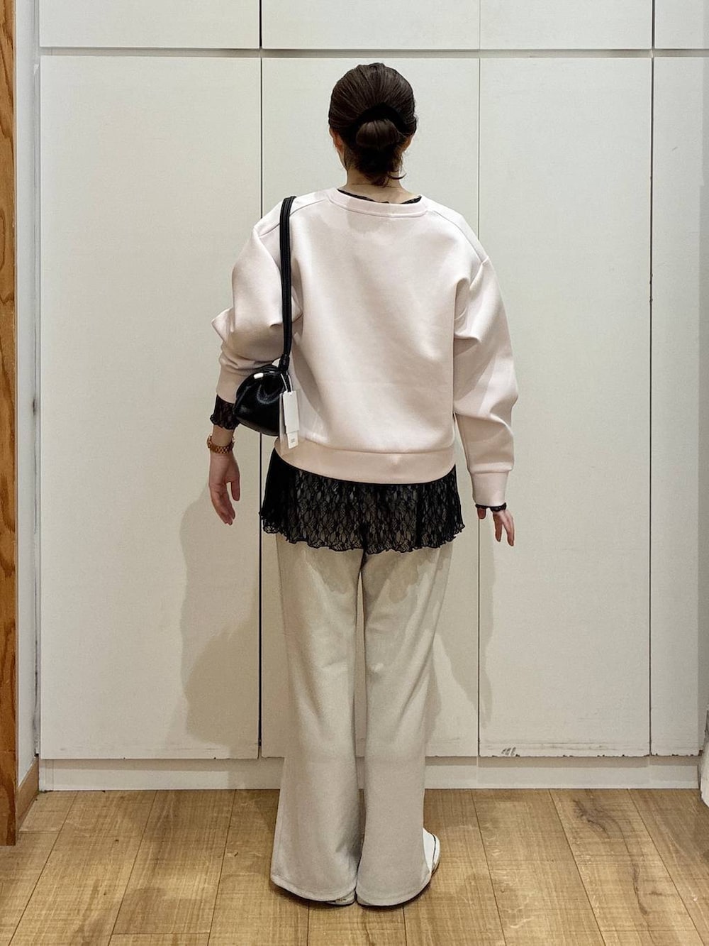 ブラック系のショルダーバッグ、ベージュ系のその他パンツ、ピンク系のカーディガン/ボレロを着用したレディースの春コーディネートの3枚目の写真