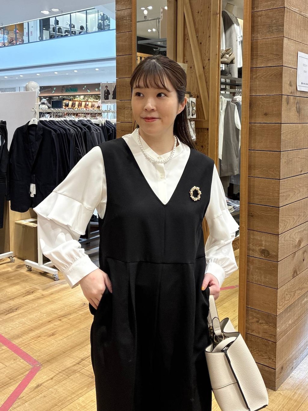 ベージュ系のローファー、ブラック系のセットアップ、ベージュ系のショルダーバッグを着用したレディースの春コーディネートの4枚目の写真