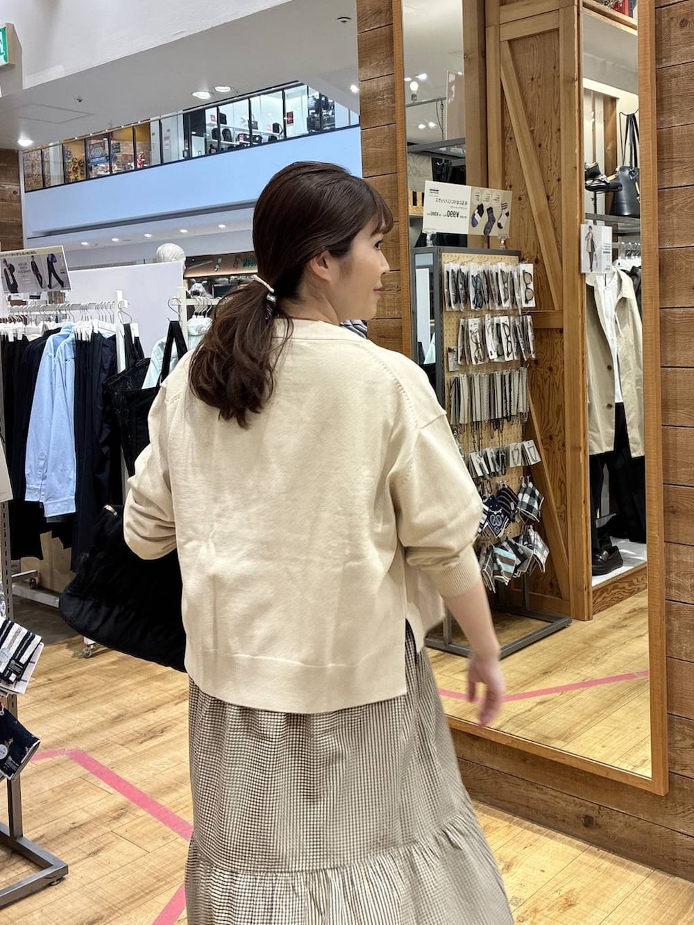 ブラック系のトートバッグ、ベージュ系のカーディガン/ボレロ、イエロー系のワンピースを着用したレディースの春コーディネートの5枚目の写真