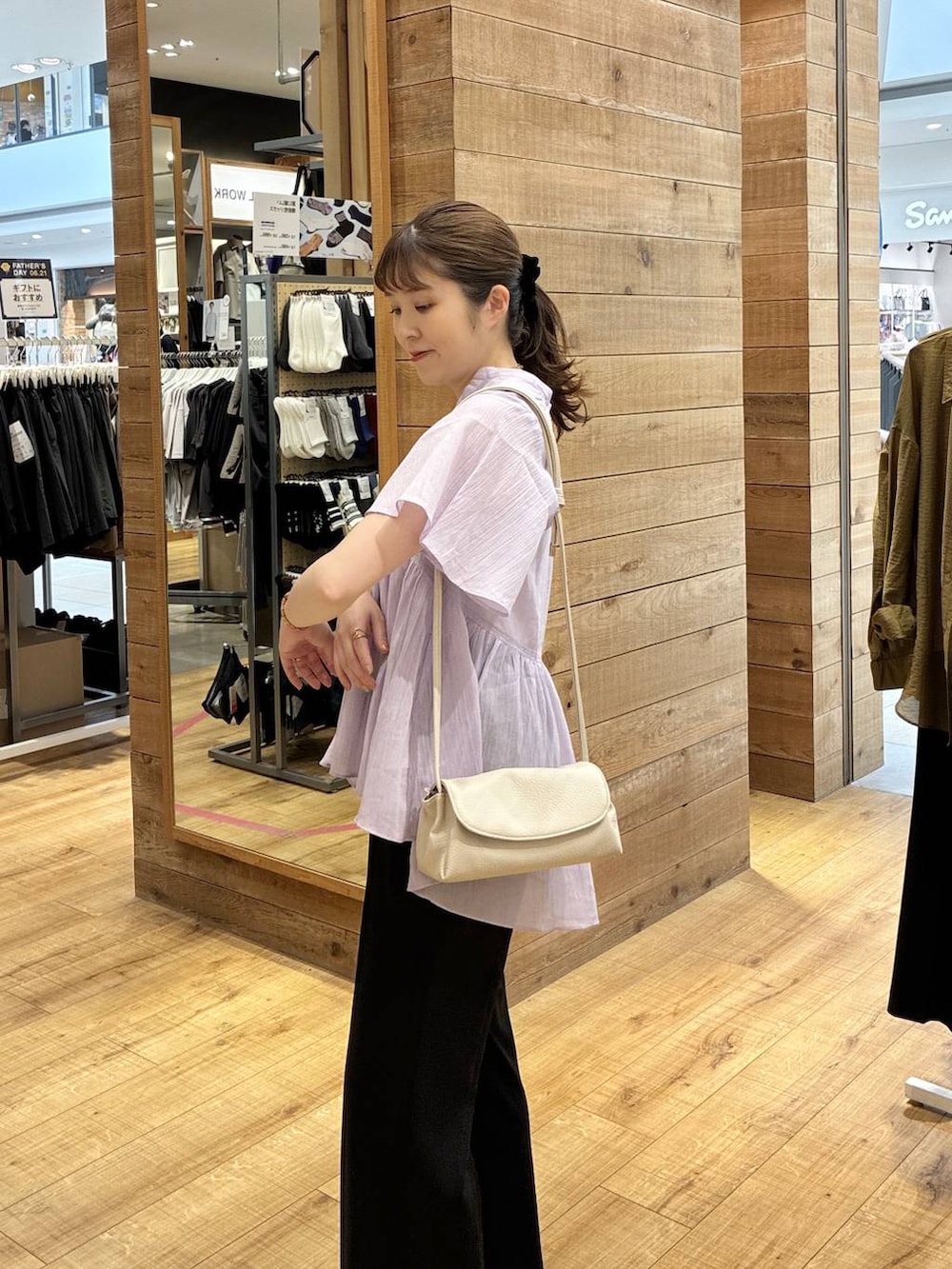 グレー系のスニーカー、ベージュ系のショルダーバッグ、ホワイト系のタンクトップを着用したレディースの夏コーディネートの4枚目の写真
