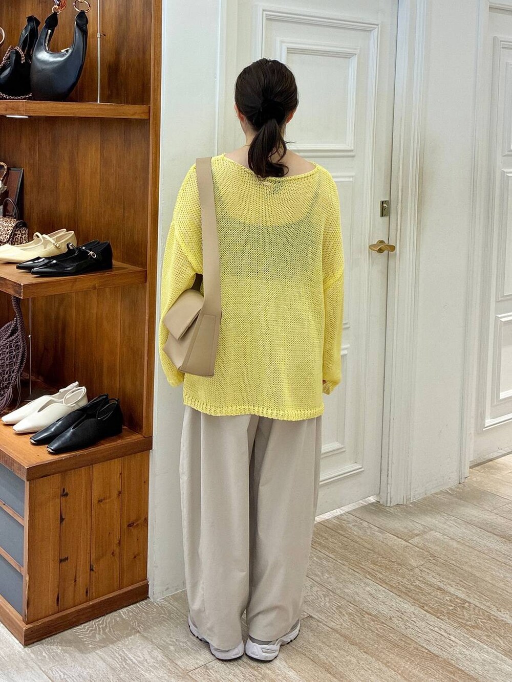 ブラウン系のショルダーバッグ、グレー系のその他パンツ、イエロー系のニット/セーターを着用したレディースの春コーディネートの3枚目の写真