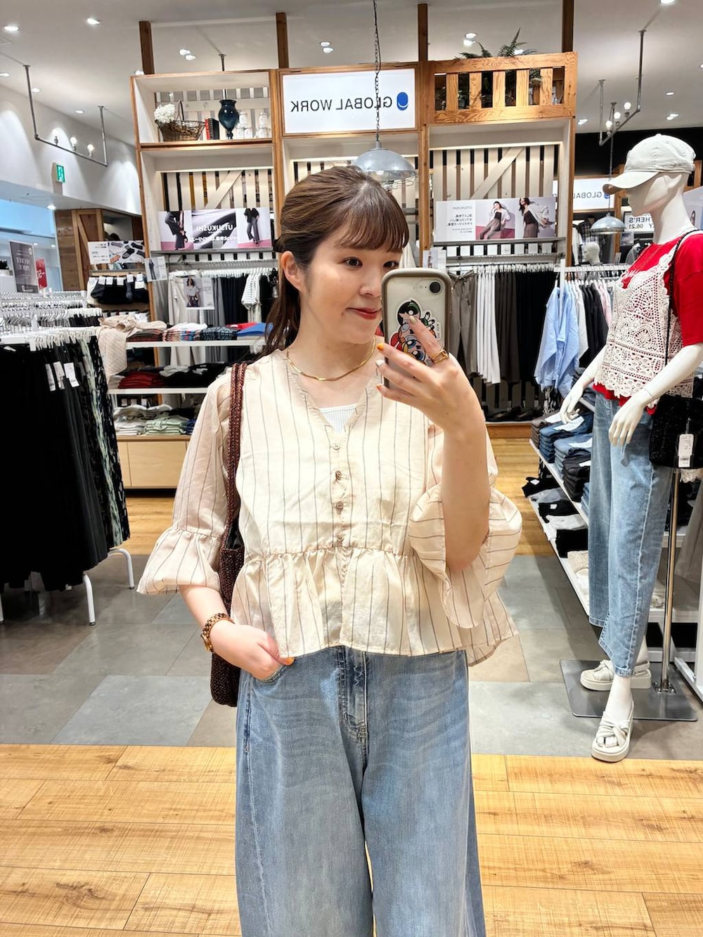 ブルー系のデニムパンツ、ホワイト系のタンクトップ、ブラウン系のトートバッグを着用したレディースの夏コーディネートの4枚目の写真