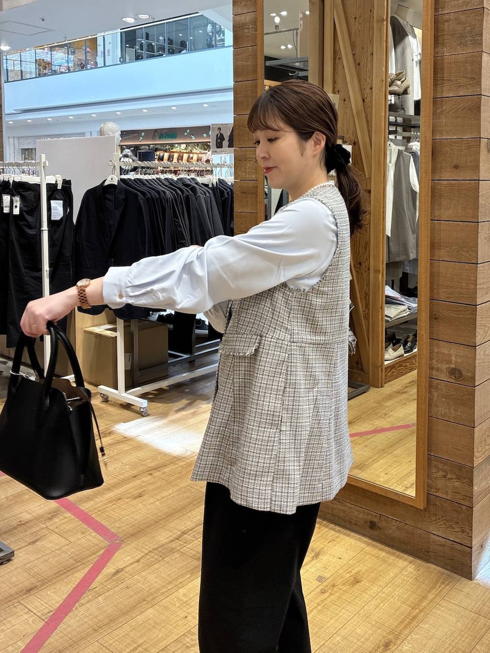 ブラック系のショルダーバッグ、ブラック系のパンプス、ブラック系のスラックスを着用したレディースの春コーディネートの5枚目の写真