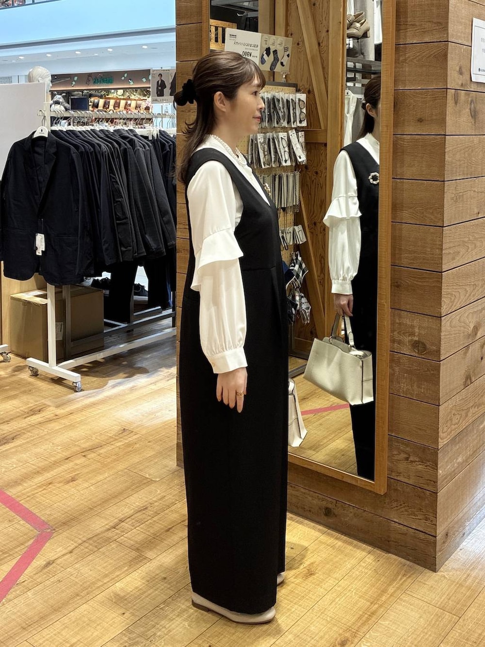 ベージュ系のローファー、ブラック系のセットアップ、ベージュ系のショルダーバッグを着用したレディースの春コーディネートの2枚目の写真