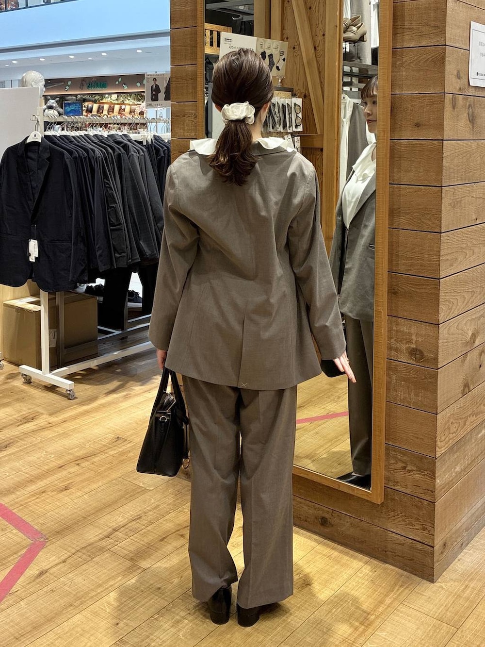 ブラック系のショルダーバッグ、ブラウン系のスラックス、ブラウン系のテーラードジャケットを着用したレディースの春コーディネートの4枚目の写真