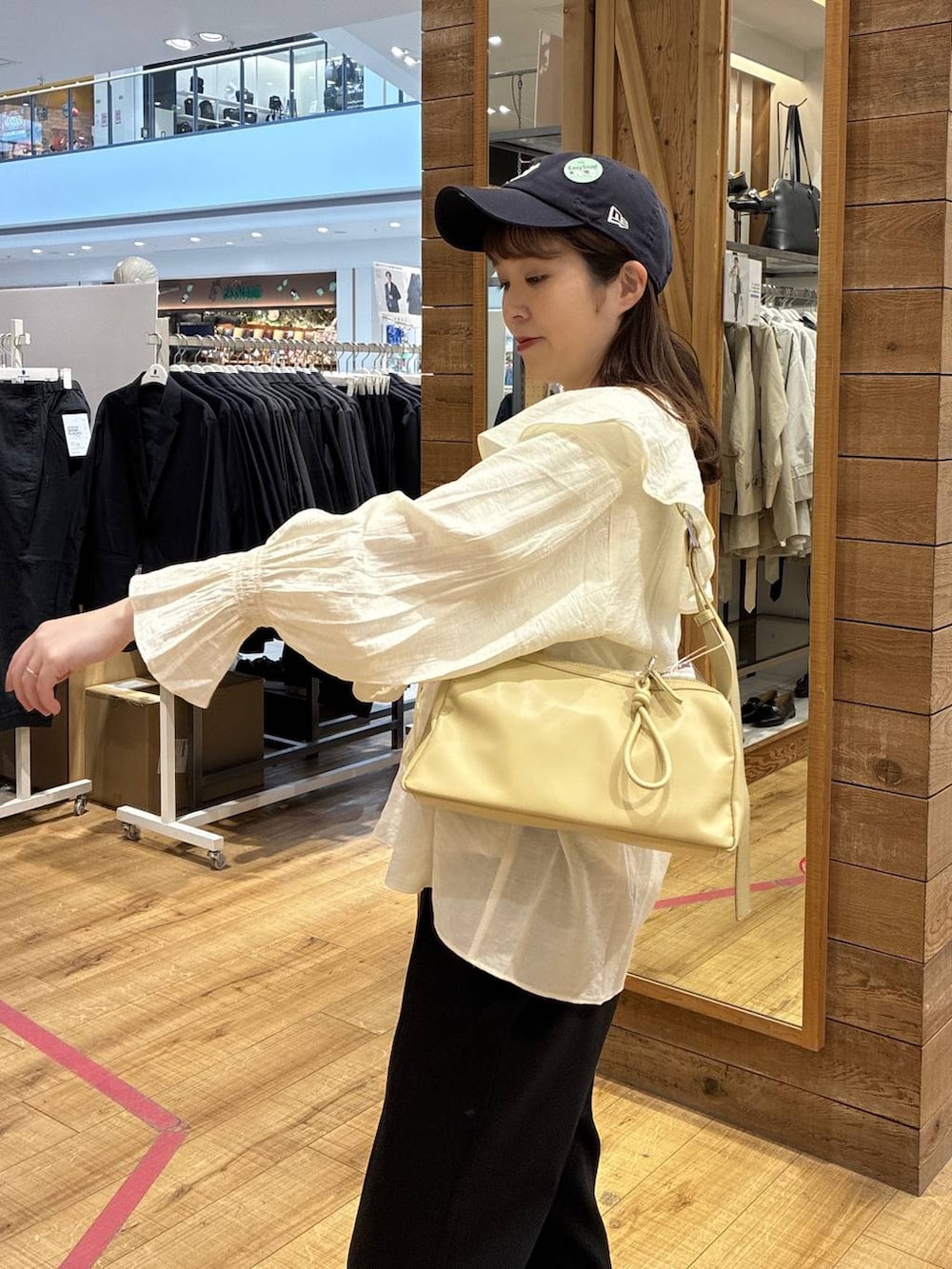 イエロー系のショルダーバッグ、ブラック系のスウェットパンツ、ホワイト系のシャツ/ブラウスを着用したレディースの春コーディネートの4枚目の写真