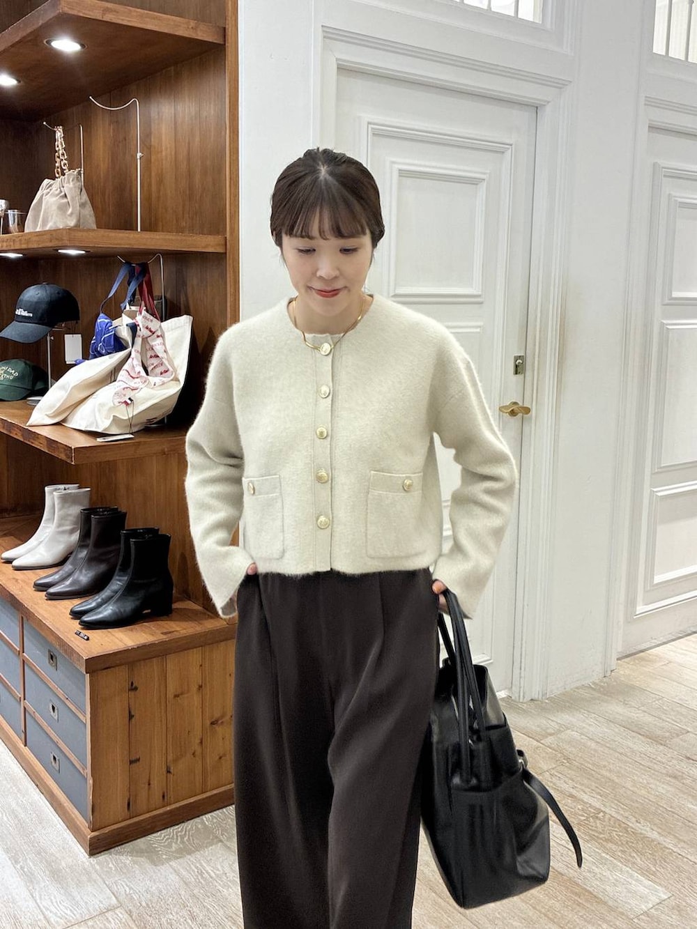 ブラック系のローファー、ブラウン系のスラックス、ホワイト系のカーディガン/ボレロを着用したレディースの秋コーディネートの4枚目の写真