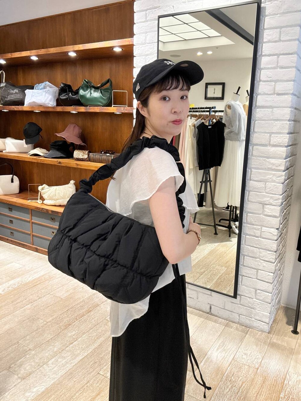 ブラック系のサンダル、ブラック系のスカート、ブラック系のショルダーバッグを着用したレディースの夏コーディネートの5枚目の写真