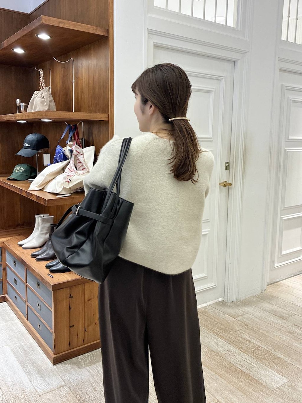 ブラック系のローファー、ブラウン系のスラックス、ホワイト系のカーディガン/ボレロを着用したレディースの秋コーディネートの6枚目の写真