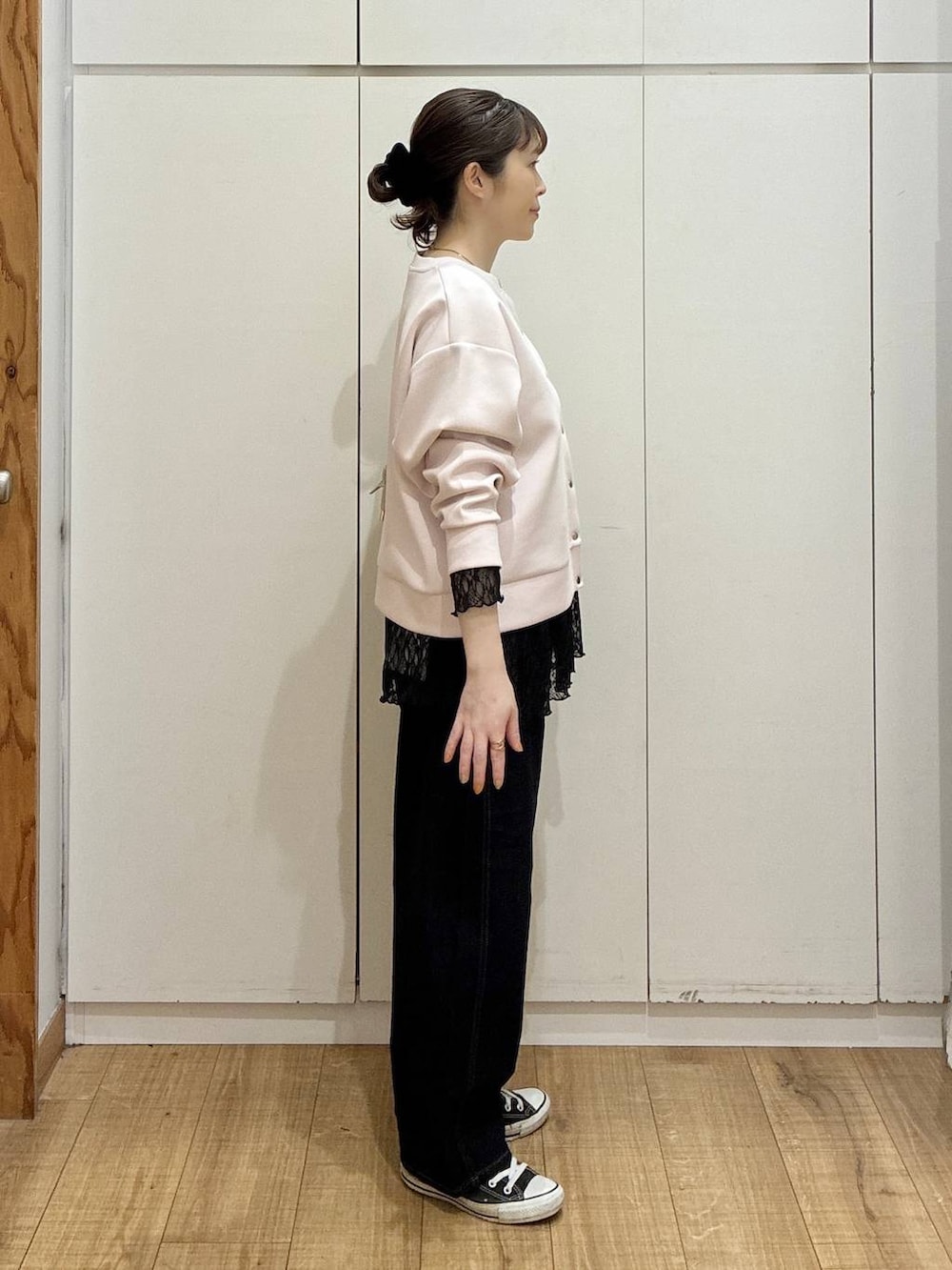 ベージュ系のショルダーバッグ、ブルー系のデニムパンツ、ピンク系のカーディガン/ボレロを着用したレディースの春コーディネートの2枚目の写真