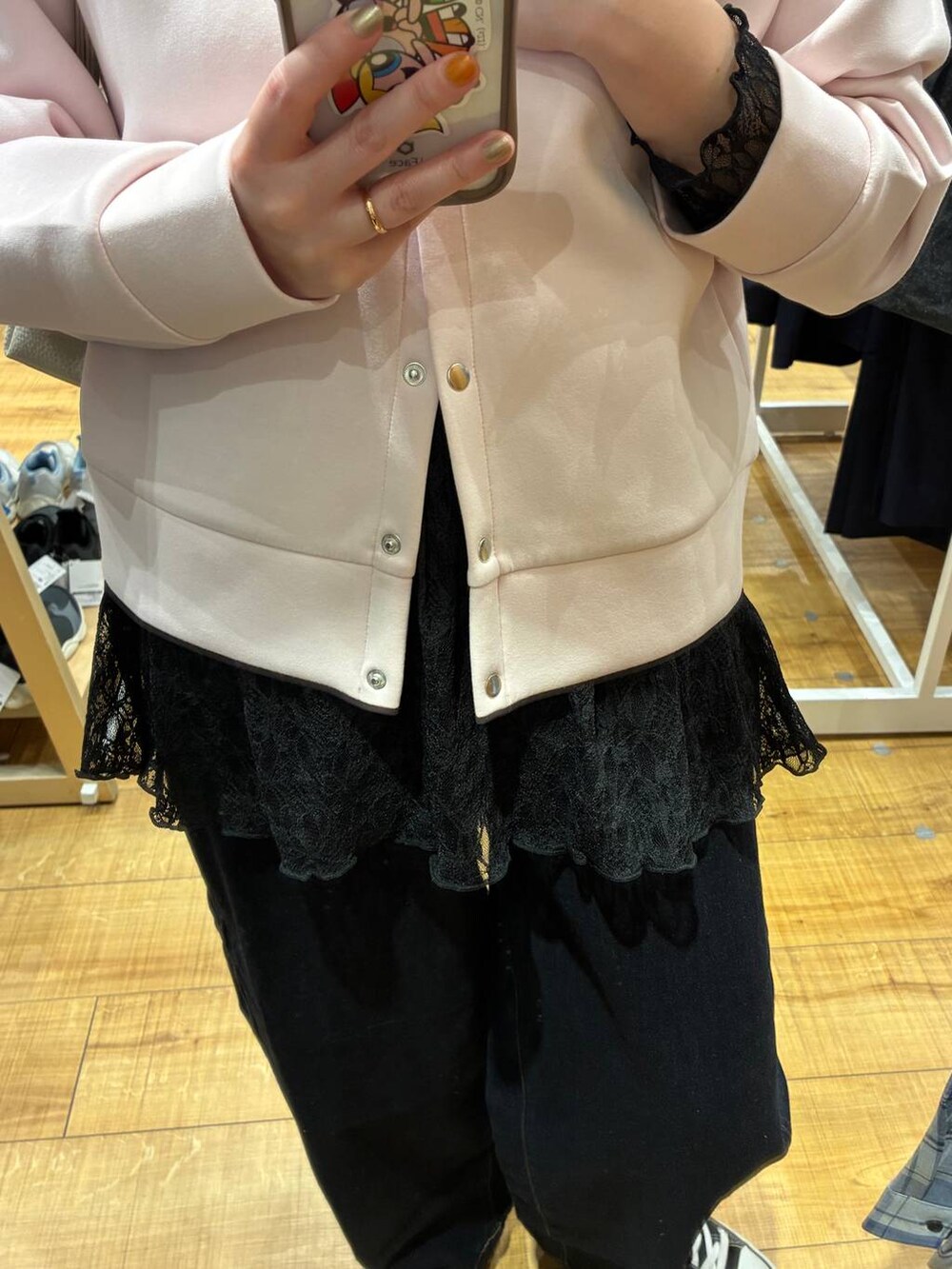 ベージュ系のショルダーバッグ、ブルー系のデニムパンツ、ピンク系のカーディガン/ボレロを着用したレディースの春コーディネートの4枚目の写真