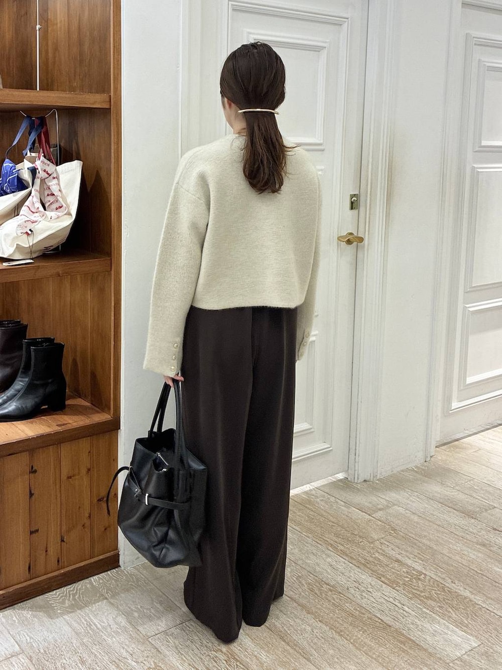 ブラック系のローファー、ブラウン系のスラックス、ホワイト系のカーディガン/ボレロを着用したレディースの秋コーディネートの3枚目の写真