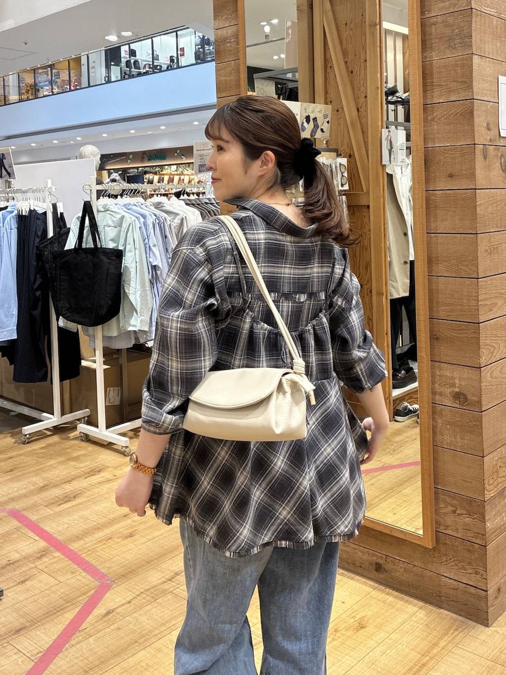 ブルー系のデニムパンツ、ベージュ系のショルダーバッグ、ブラック系のシャツ/ブラウスを着用したレディースの春コーディネートの5枚目の写真