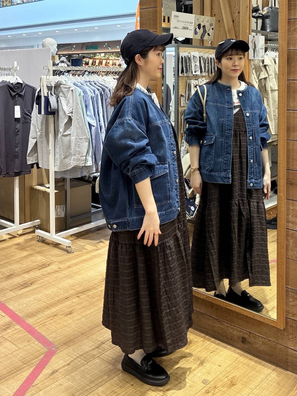 ベージュ系のショルダーバッグ、ブルー系のデニムジャケット、ブラウン系のワンピースを着用したレディースの春コーディネートの2枚目の写真