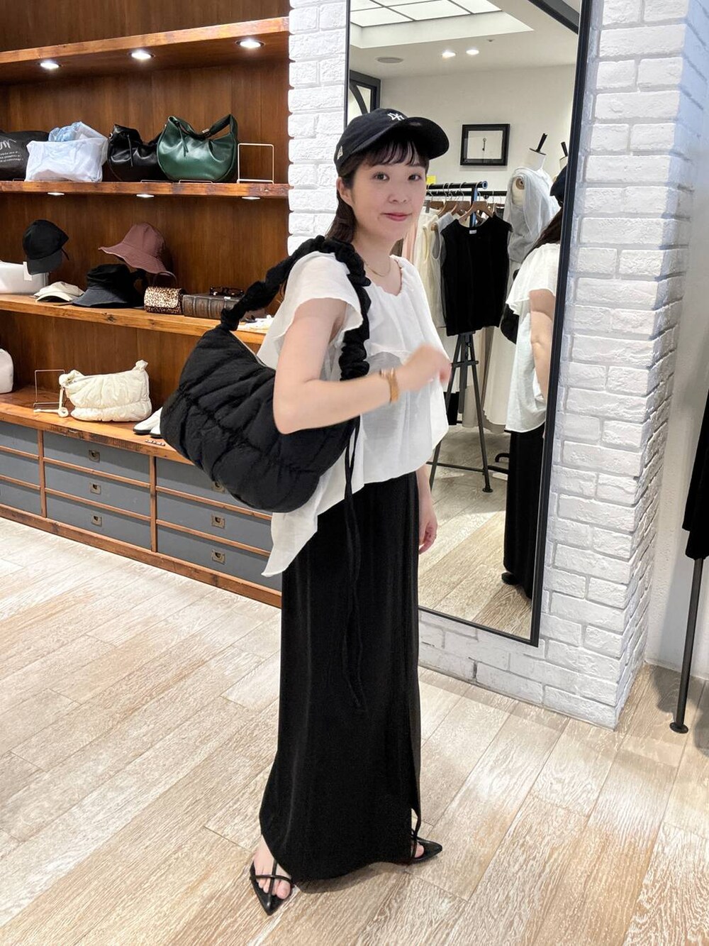 ブラック系のサンダル、ブラック系のスカート、ブラック系のショルダーバッグを着用したレディースの夏コーディネートの3枚目の写真