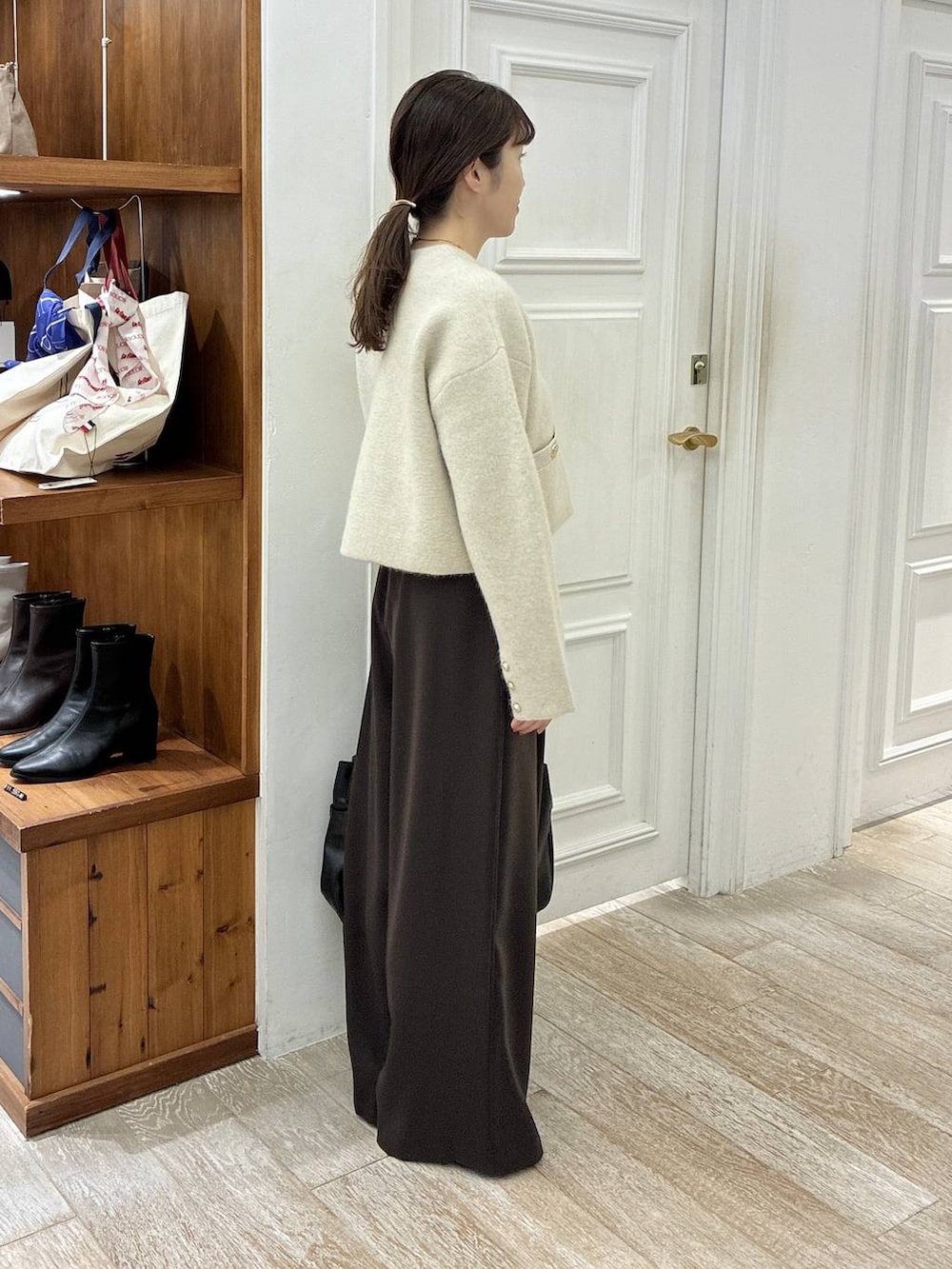 ブラック系のローファー、ブラウン系のスラックス、ホワイト系のカーディガン/ボレロを着用したレディースの秋コーディネートの2枚目の写真