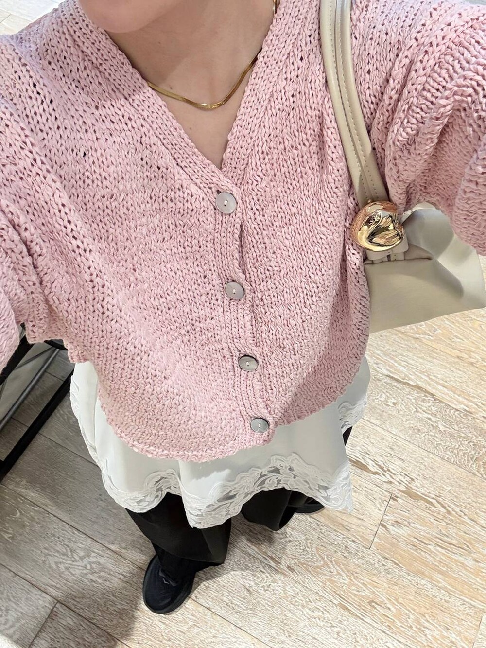 ブラック系のスラックス、ホワイト系のキャミソール、ピンク系のカーディガン/ボレロを着用したレディースの冬コーディネートの4枚目の写真