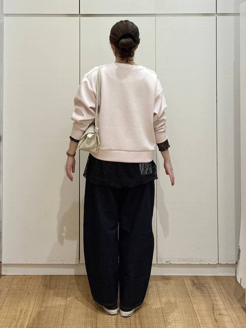 ベージュ系のショルダーバッグ、ブルー系のデニムパンツ、ピンク系のカーディガン/ボレロを着用したレディースの春コーディネートの3枚目の写真