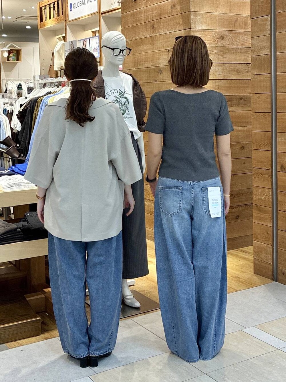 ブルー系のデニムパンツ、ベージュ系のテーラードジャケット、ブラック系のサンダルを着用したレディースの春コーディネートの3枚目の写真