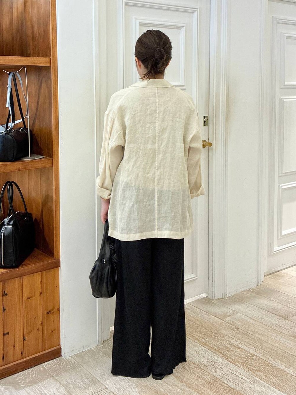 ブラック系のハンドバッグ、ブラック系のサンダル、ベージュ系のテーラードジャケットを着用したレディースの夏コーディネートの3枚目の写真