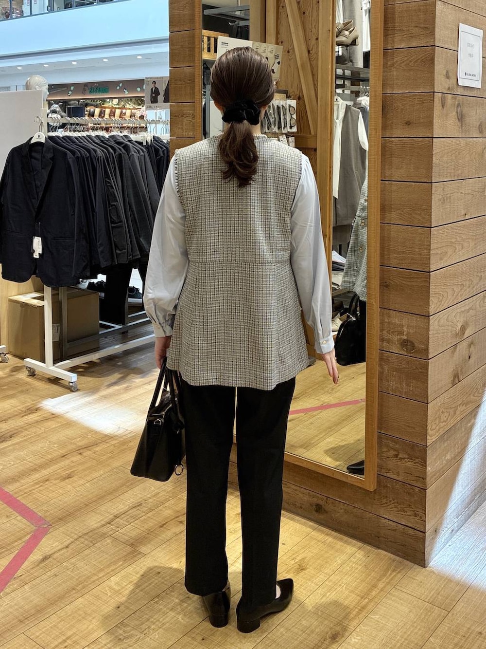 ブラック系のショルダーバッグ、ブラック系のパンプス、ブラック系のスラックスを着用したレディースの春コーディネートの3枚目の写真