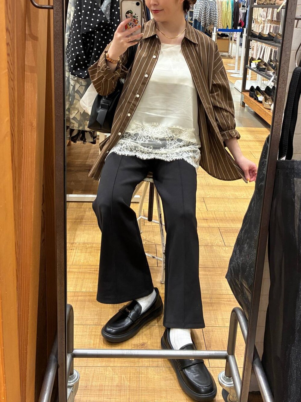 ブルー系のデニムパンツ、ホワイト系のキャミソール、ブラック系のスニーカーを着用したレディースの春コーディネートの4枚目の写真