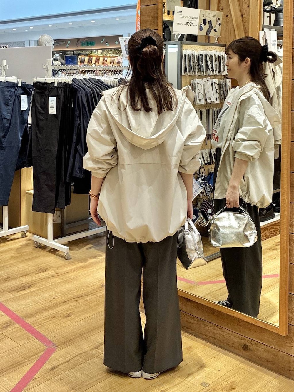 シルバー系のショルダーバッグ、ベージュ系のマウンテンパーカー、グレー系のその他パンツを着用したレディースの春コーディネートの3枚目の写真