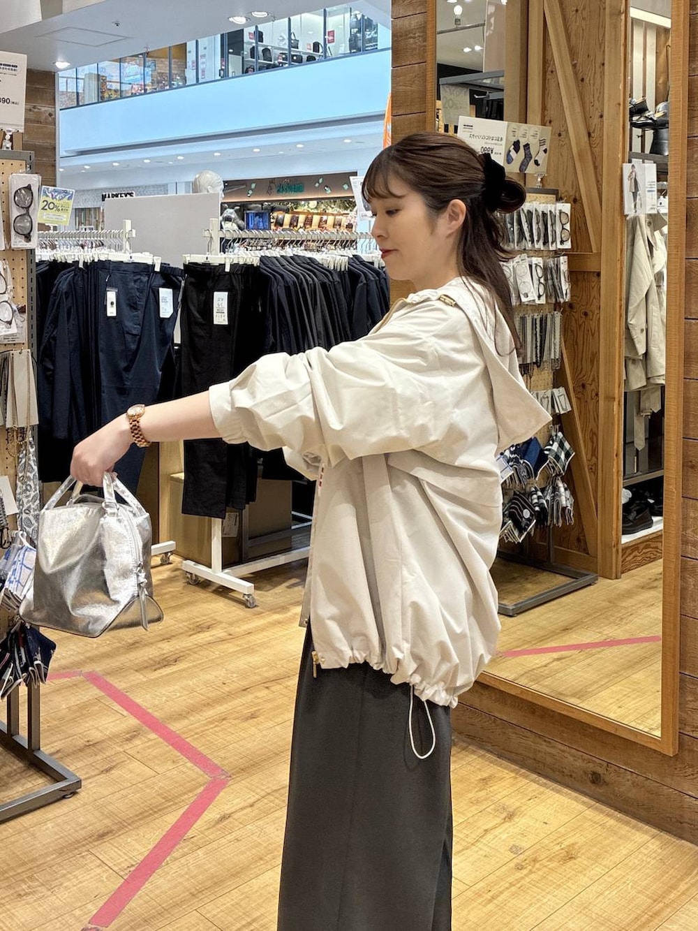 シルバー系のショルダーバッグ、ベージュ系のマウンテンパーカー、グレー系のその他パンツを着用したレディースの春コーディネートの5枚目の写真