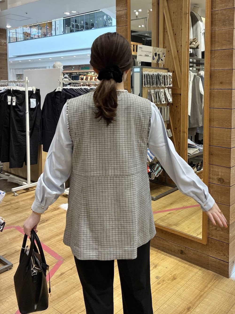 ブラック系のショルダーバッグ、ブラック系のパンプス、ブラック系のスラックスを着用したレディースの春コーディネートの6枚目の写真