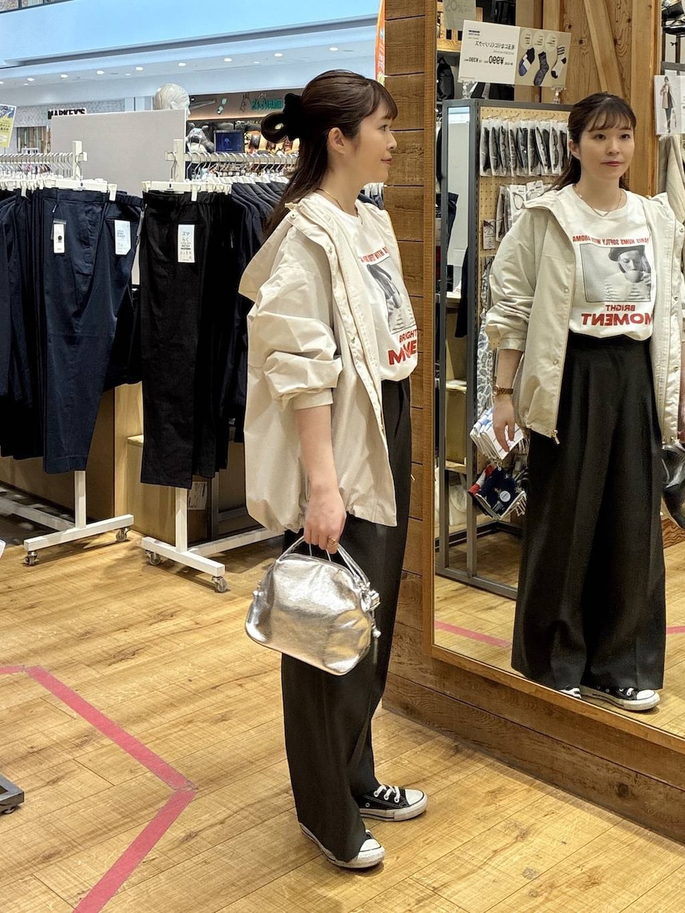 シルバー系のショルダーバッグ、ベージュ系のマウンテンパーカー、グレー系のその他パンツを着用したレディースの春コーディネートの2枚目の写真