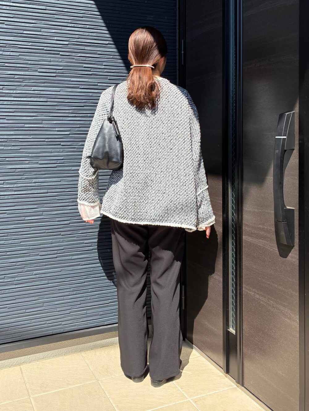 ブラック系のローファー、ブラック系のショルダーバッグ、ブラック系のノーカラージャケットを着用したレディースの春コーディネートの5枚目の写真