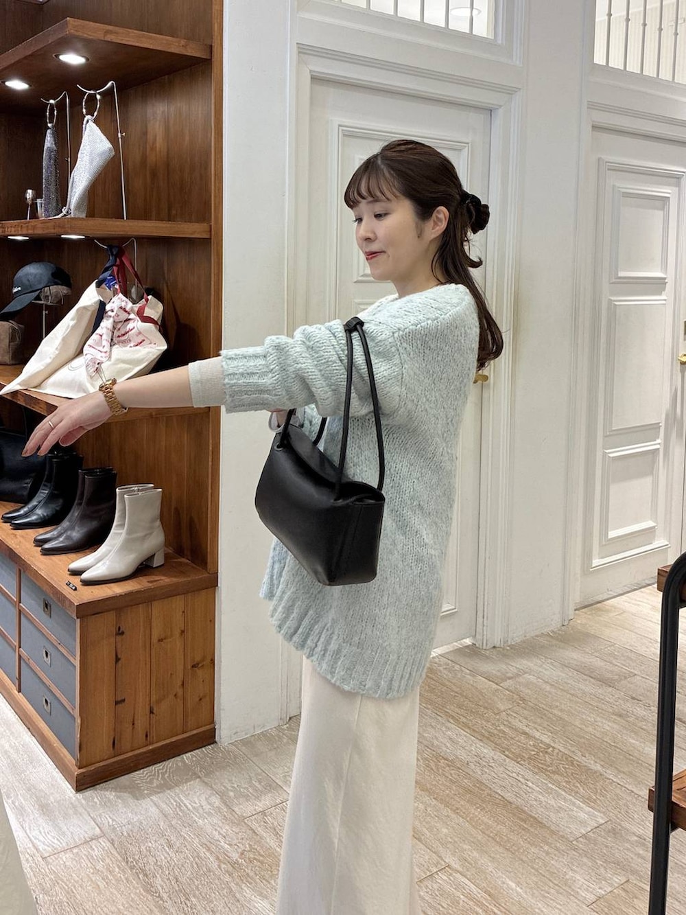 ホワイト系のスカート、グリーン系のニット/セーター、ブラック系のショルダーバッグを着用したレディースの冬コーディネートの5枚目の写真