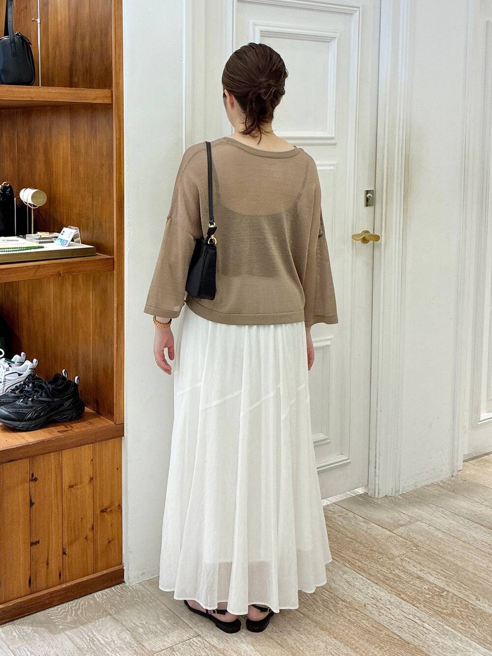 ブラック系のサンダル、ホワイト系のスカート、イエロー系のニット/セーターを着用したレディースの夏コーディネートの3枚目の写真