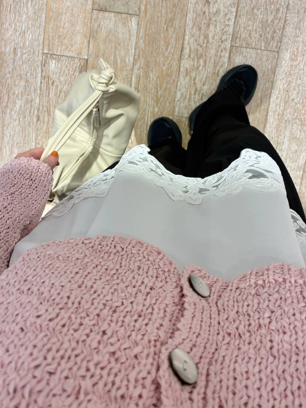 ブラック系のスラックス、ホワイト系のキャミソール、ピンク系のカーディガン/ボレロを着用したレディースの冬コーディネートの3枚目の写真