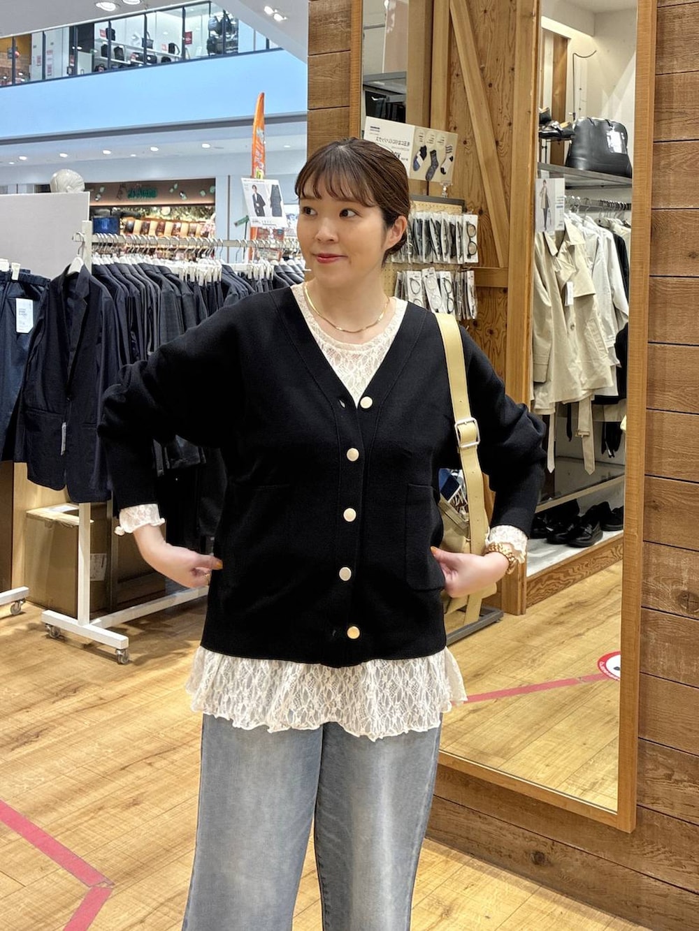 ブラック系のバレエシューズ、ブルー系のデニムパンツ、ブラック系のカーディガン/ボレロを着用したレディースの春コーディネートの4枚目の写真