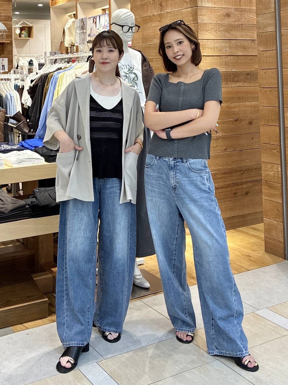 ブルー系のデニムパンツ、ベージュ系のテーラードジャケット、ブラック系のサンダルを着用したレディースの春コーディネートの4枚目の写真