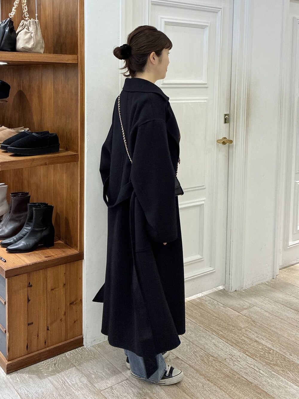 ブルー系のステンカラーコート、ブルー系のデニムパンツ、ホワイト系のTシャツ/カットソーを着用したレディースの秋コーディネートの2枚目の写真