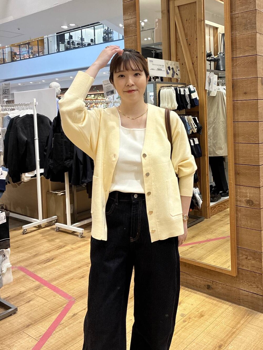 ブラウン系のボストンバッグ、ブルー系のデニムパンツ、イエロー系のカーディガン/ボレロを着用したレディースの春コーディネートの6枚目の写真