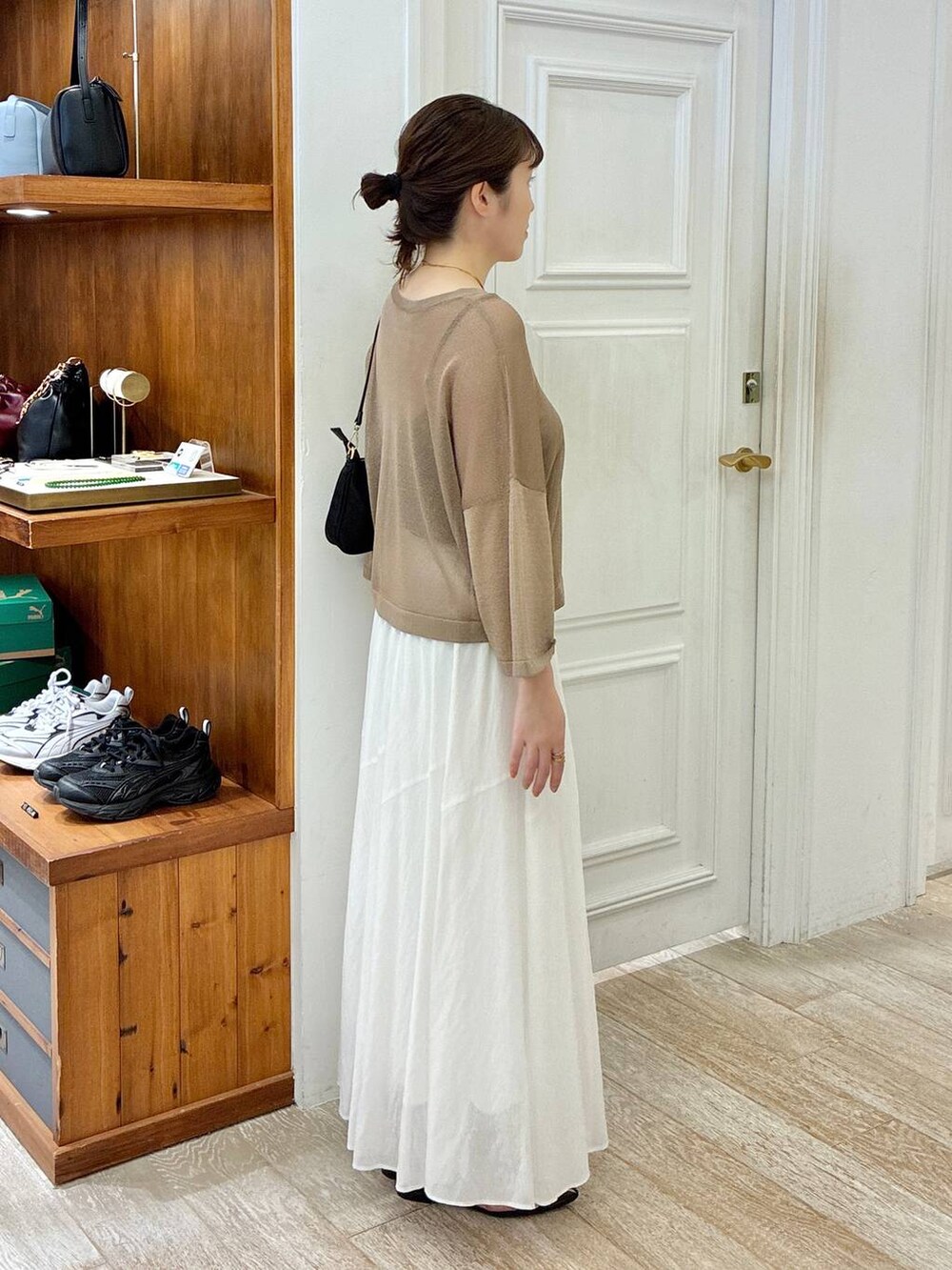 ブラック系のサンダル、ホワイト系のスカート、イエロー系のニット/セーターを着用したレディースの夏コーディネートの2枚目の写真