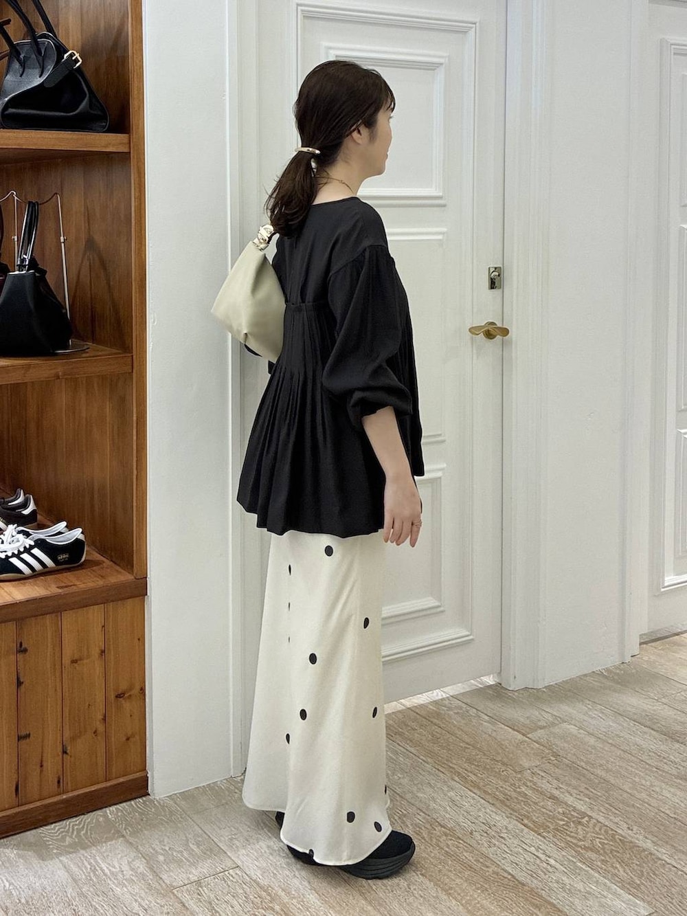 ホワイト系のスカート、ブラック系のシャツ/ブラウス、ゴールド系のバレッタ/ヘアクリップを着用したレディースの冬コーディネートの2枚目の写真