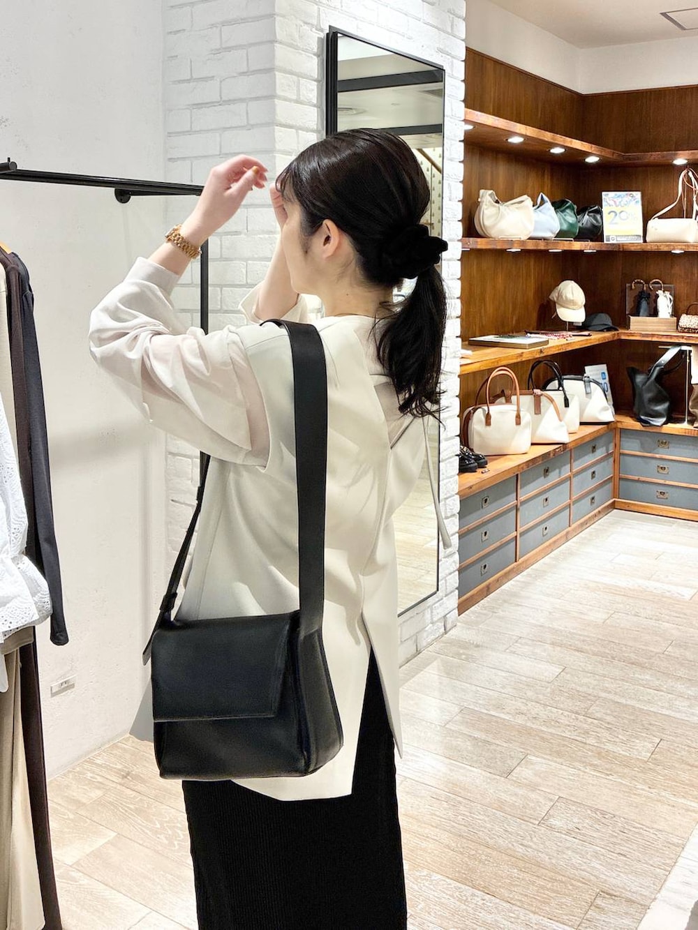 ベージュ系のパンツドレス、ブラック系のスカート、ホワイト系のシャツ/ブラウスを着用したレディースの春コーディネートの5枚目の写真