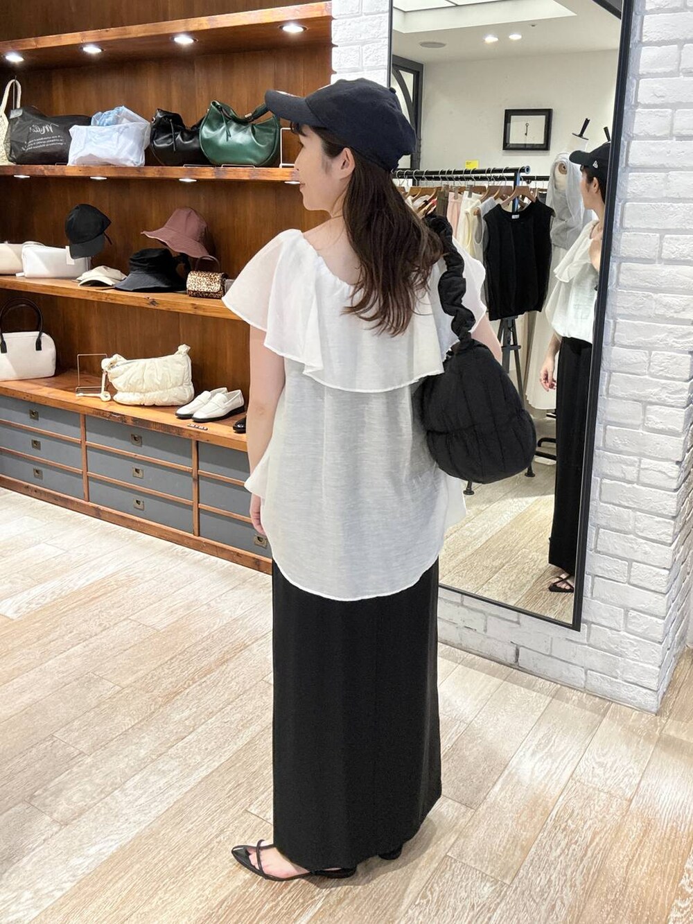 ブラック系のサンダル、ブラック系のスカート、ブラック系のショルダーバッグを着用したレディースの夏コーディネートの4枚目の写真