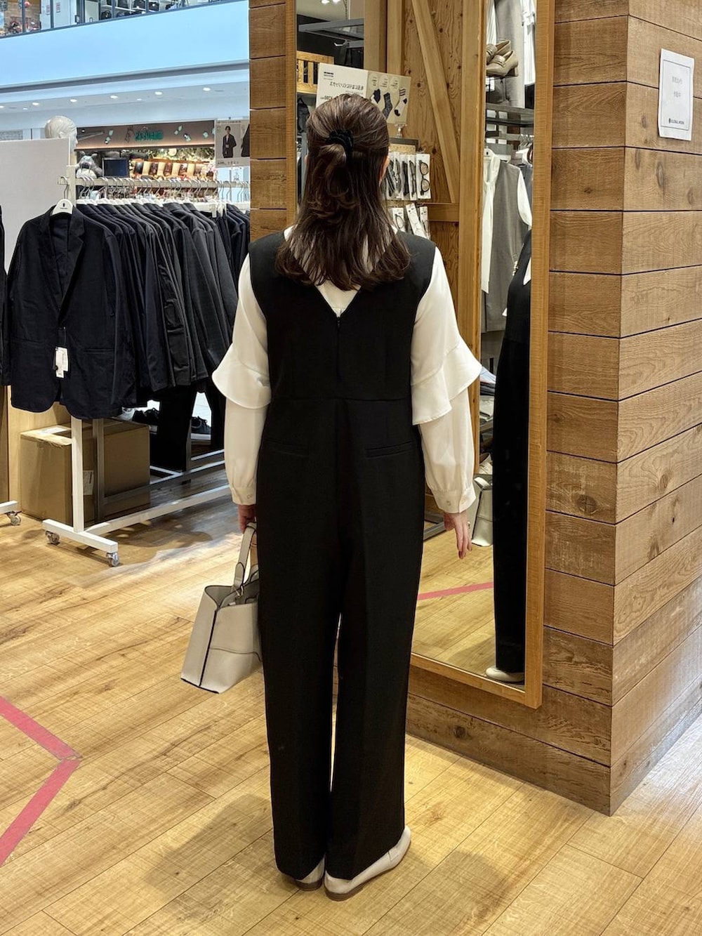 ベージュ系のローファー、ブラック系のセットアップ、ベージュ系のショルダーバッグを着用したレディースの春コーディネートの3枚目の写真