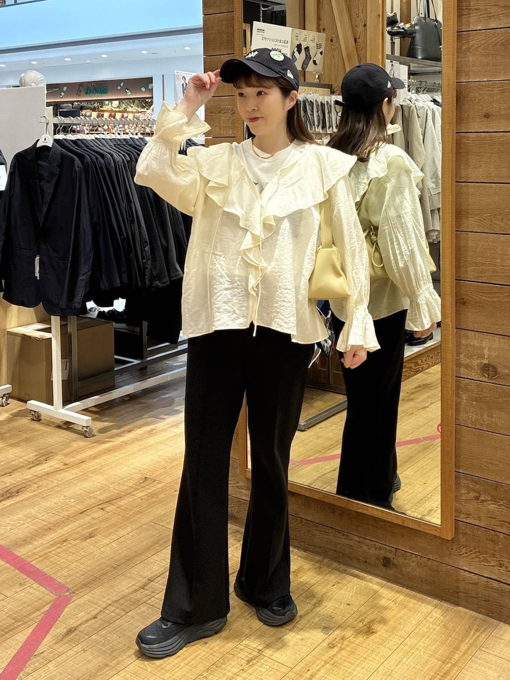 イエロー系のショルダーバッグ、ブラック系のスウェットパンツ、ホワイト系のシャツ/ブラウスを着用したレディースの春コーディネートの5枚目の写真