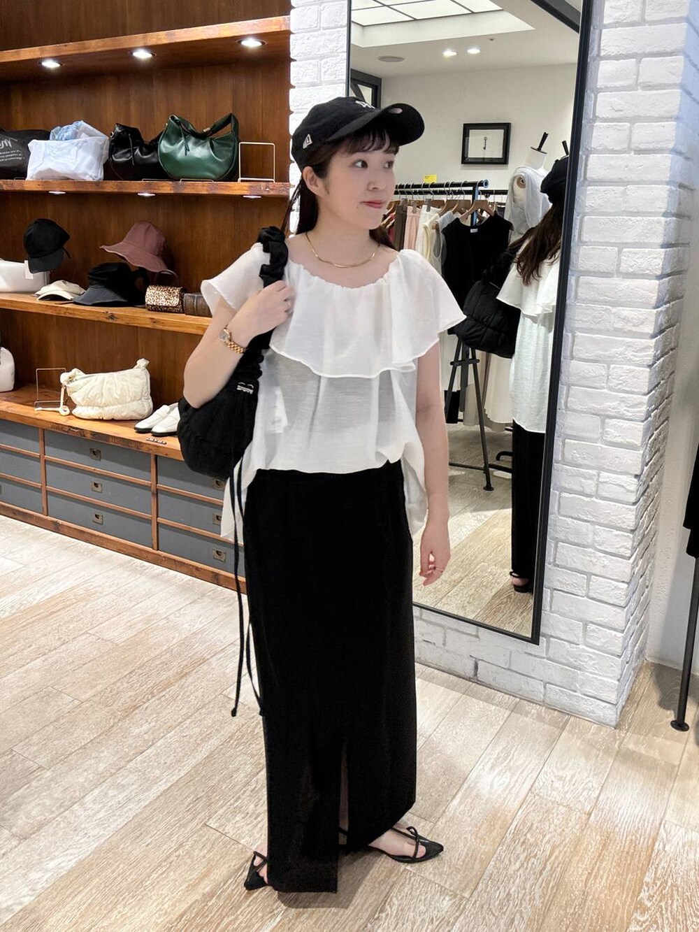 ブラック系のサンダル、ブラック系のスカート、ブラック系のショルダーバッグを着用したレディースの夏コーディネートの2枚目の写真