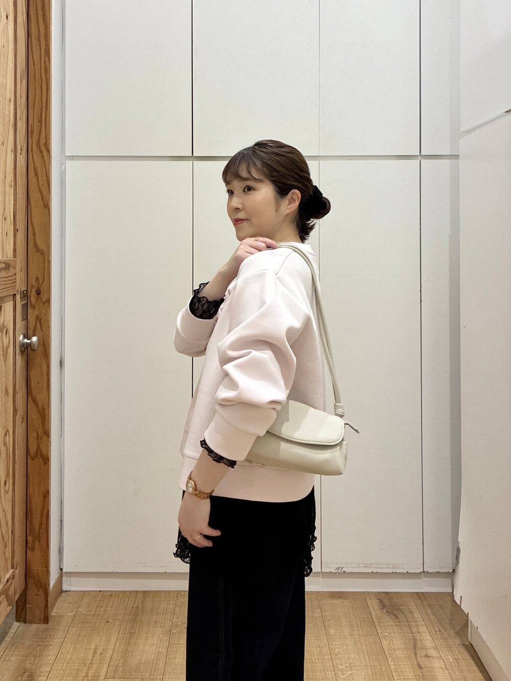 ベージュ系のショルダーバッグ、ブルー系のデニムパンツ、ピンク系のカーディガン/ボレロを着用したレディースの春コーディネートの6枚目の写真