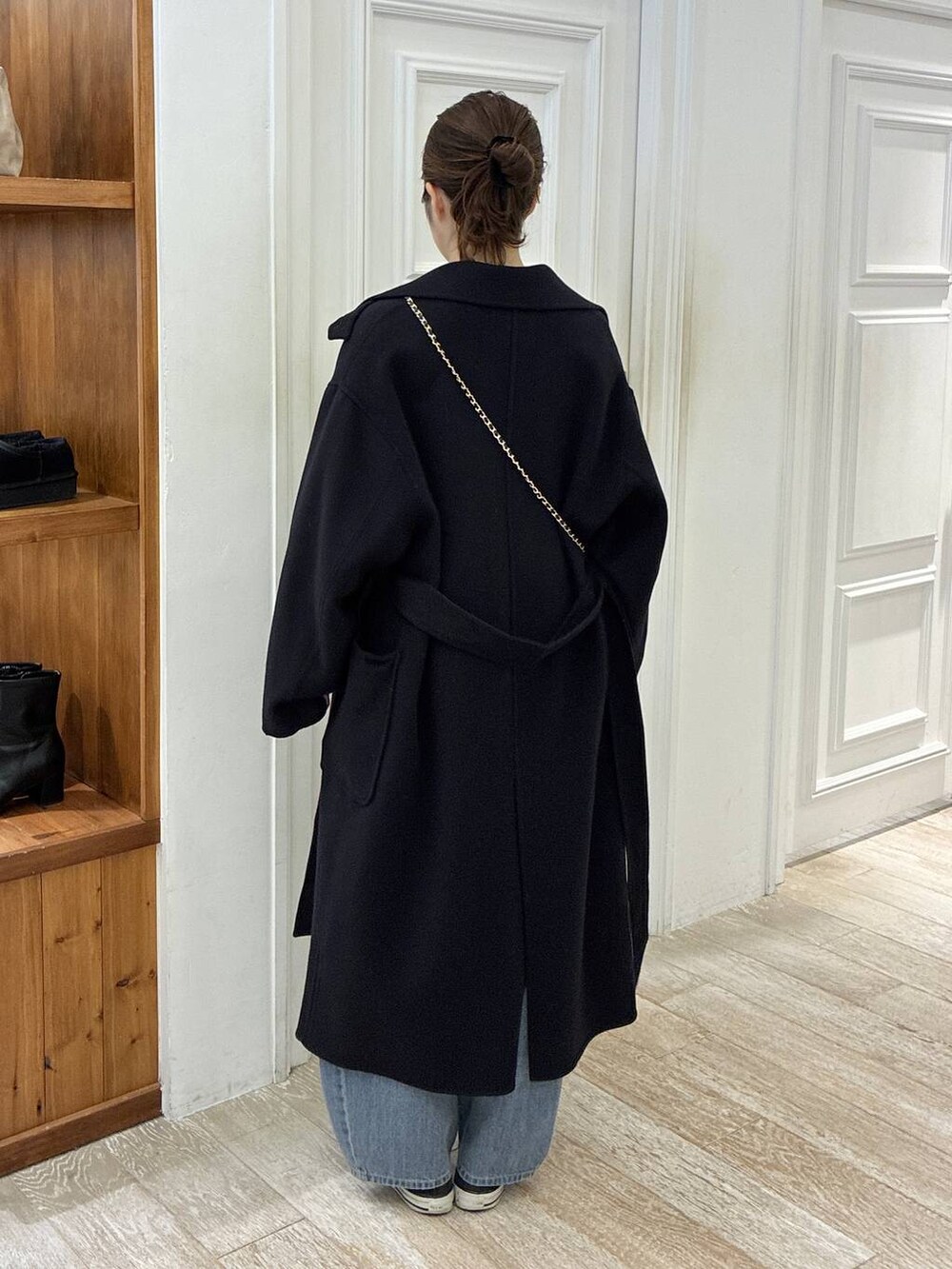 ブルー系のステンカラーコート、ブルー系のデニムパンツ、ホワイト系のTシャツ/カットソーを着用したレディースの秋コーディネートの3枚目の写真