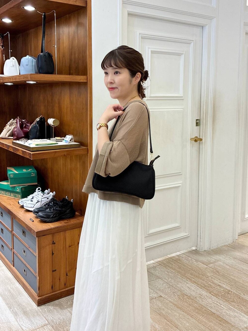 ブラック系のサンダル、ホワイト系のスカート、イエロー系のニット/セーターを着用したレディースの夏コーディネートの5枚目の写真