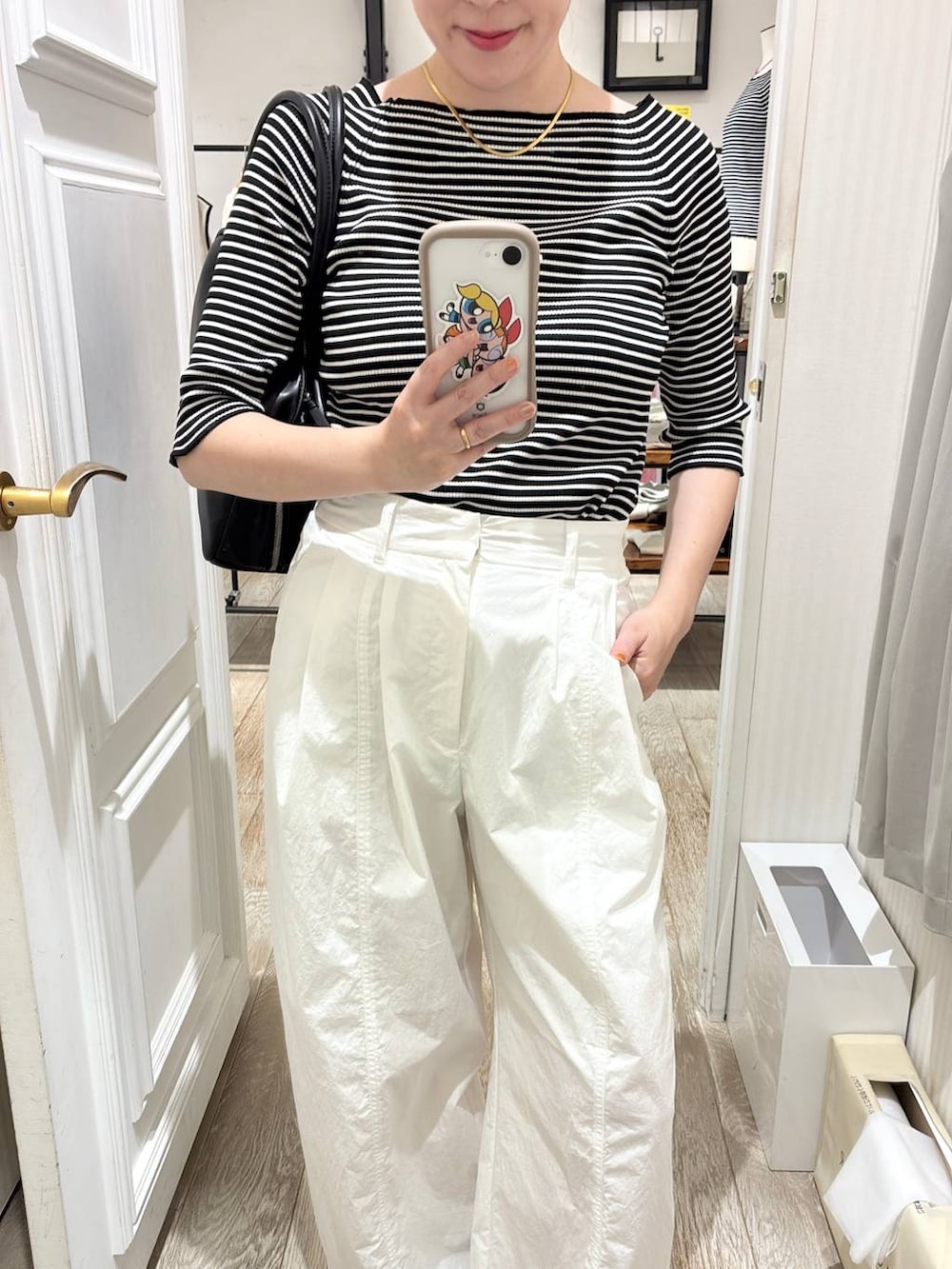 ブラック系のボストンバッグ、ホワイト系のその他パンツ、ブラック系のニット/セーターを着用したレディースの夏コーディネートの3枚目の写真